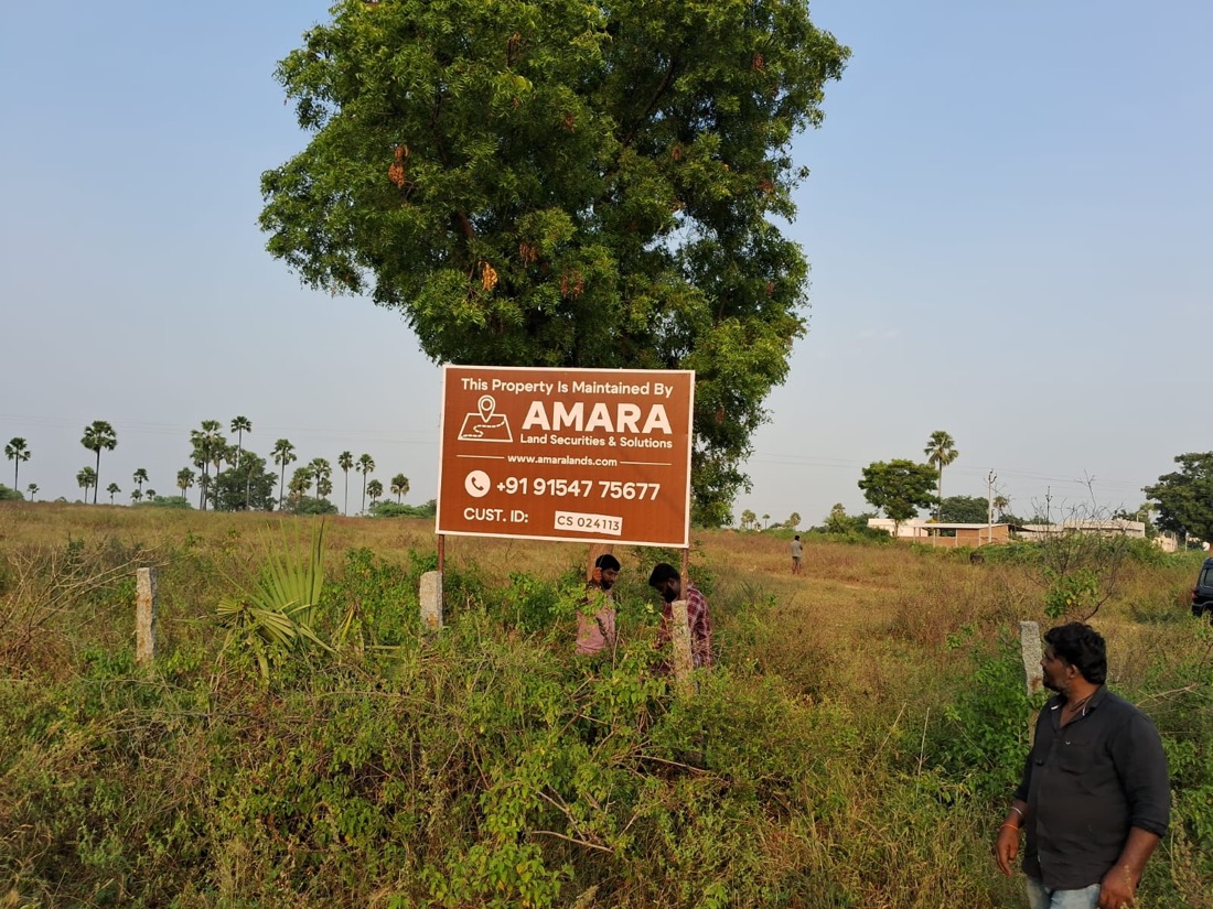 Amara Land Securities maintenance board installed on an open client plot near Hyderabad, with the field team on site
