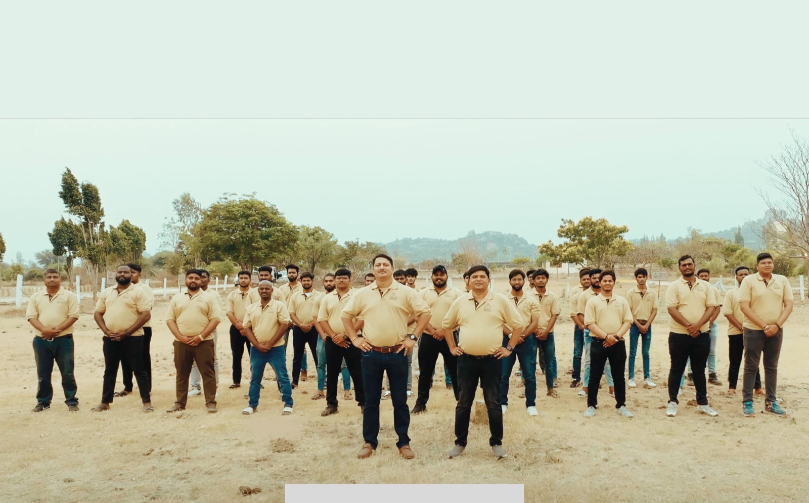 The Amara Lands Security field team in uniform, standing together on an open plot in the Hyderabad HMDA belt